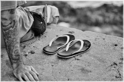 man sitting on ledge with shoes off