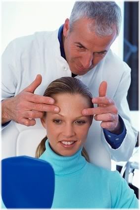 doctor looking at patient's forehead