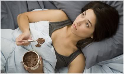 woman eating chocolate in bed