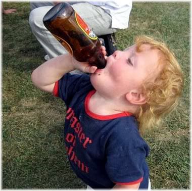 young boy with beer bottle in mouth