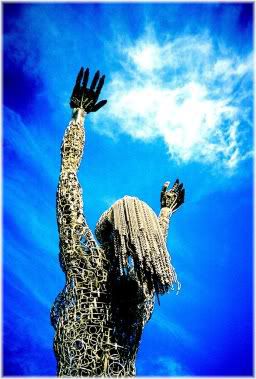 female figurine reaching towards sky