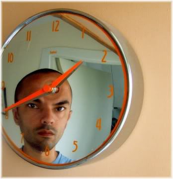 reflejo de la cara del hombre en el reloj de pared