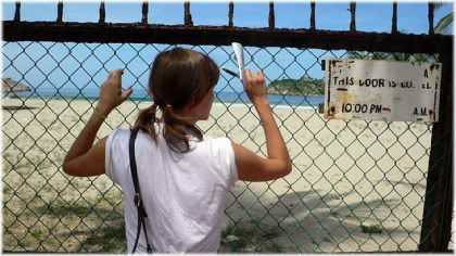 girl looking through fence